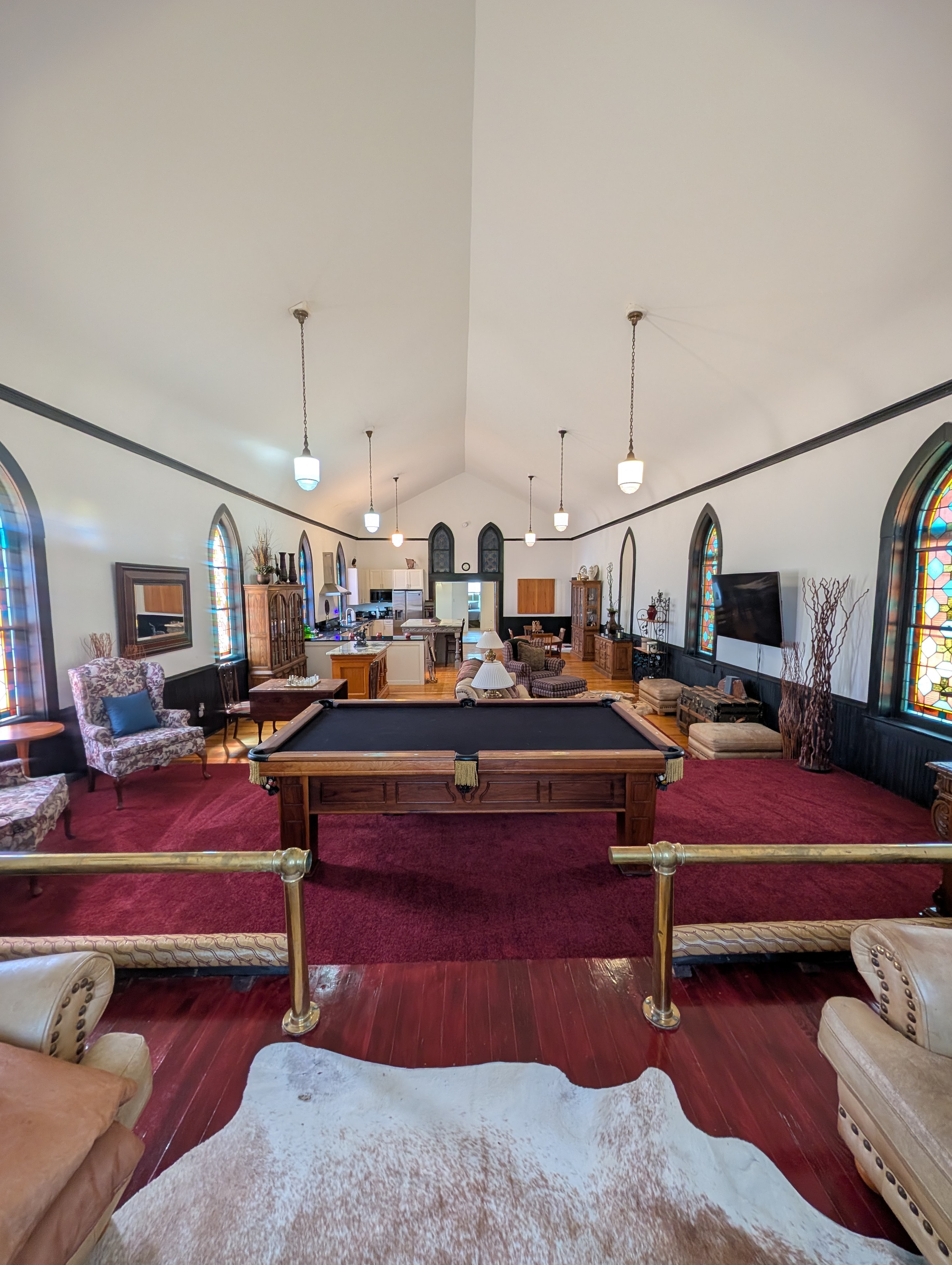 Chapel great room with pool table, stained glass windows, and open kitchen beyond