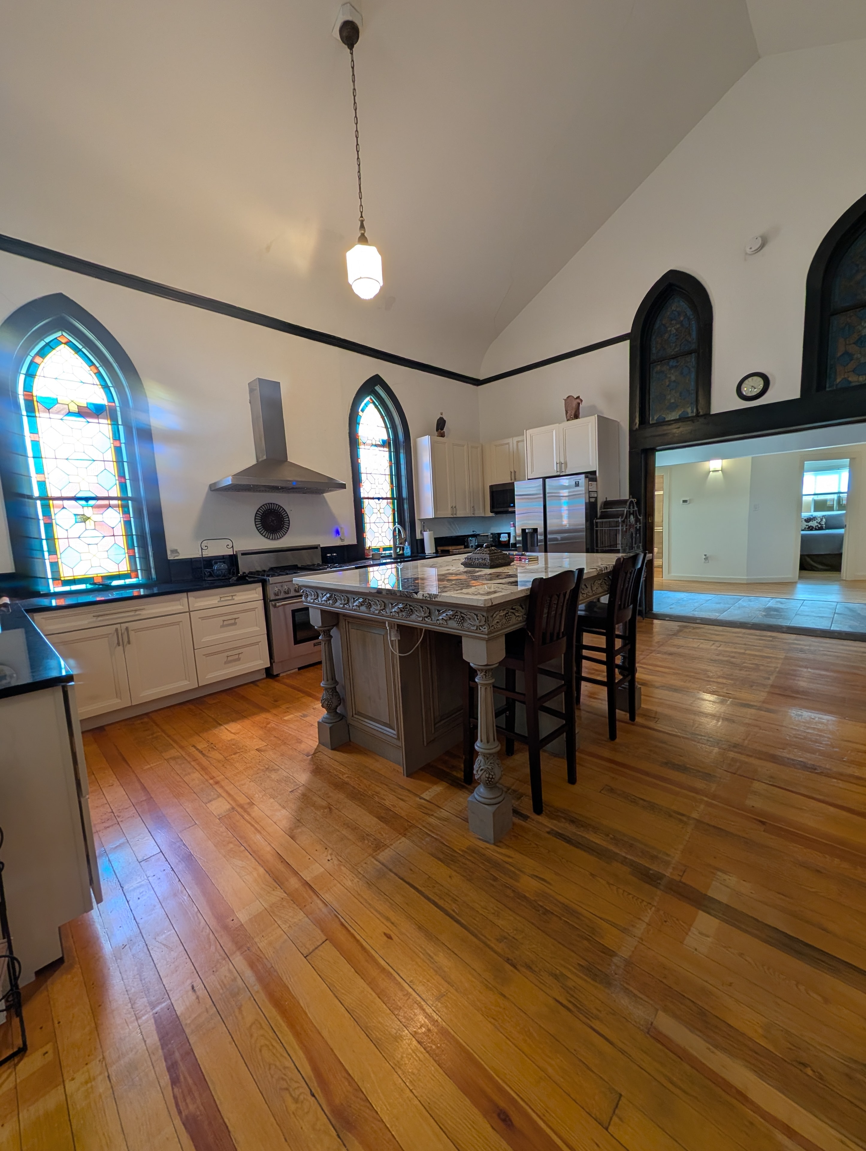 Full kitchen with marble island, stainless appliances, and stained glass windows