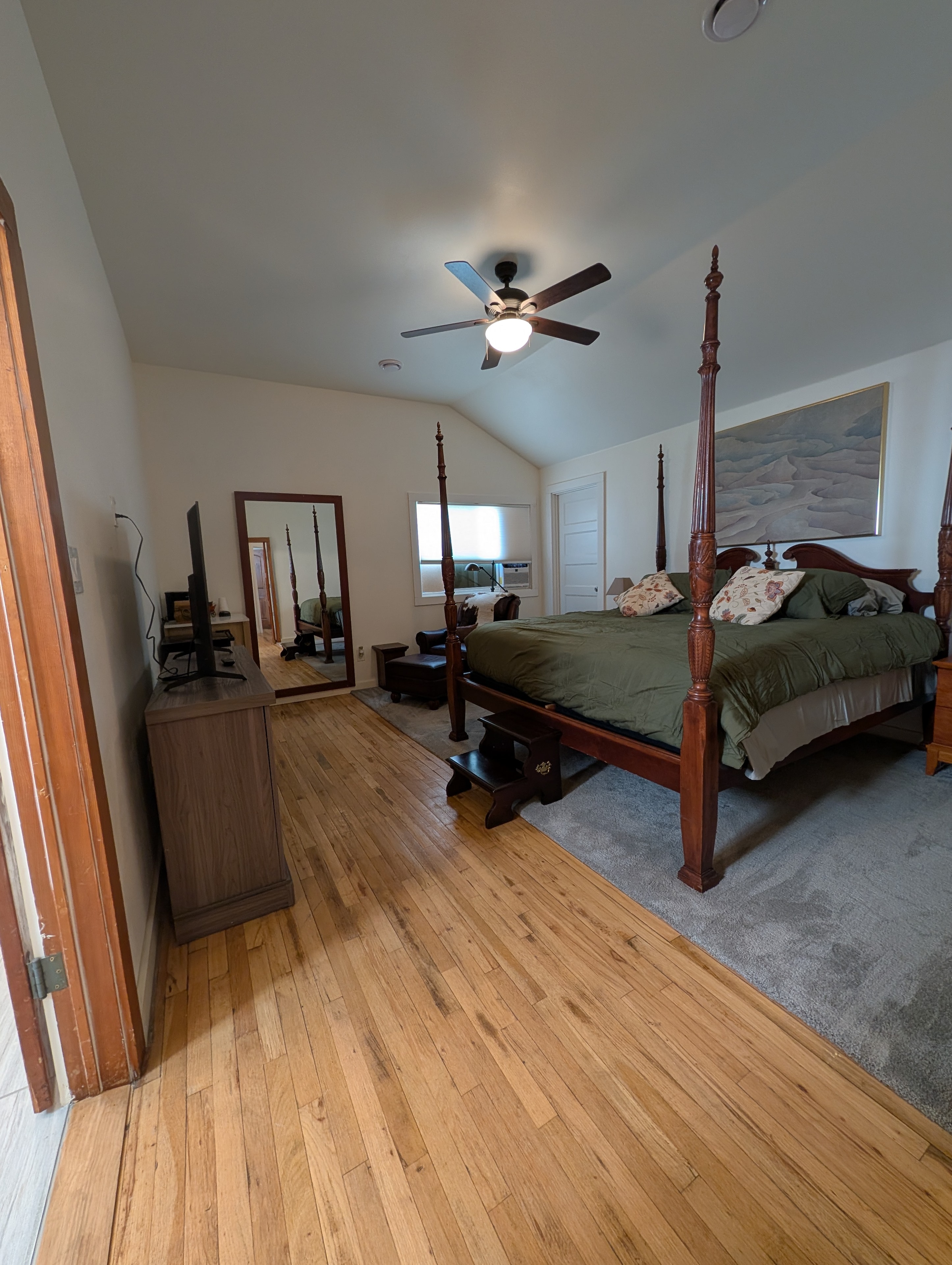 King master bedroom with four-poster bed and hardwood floors