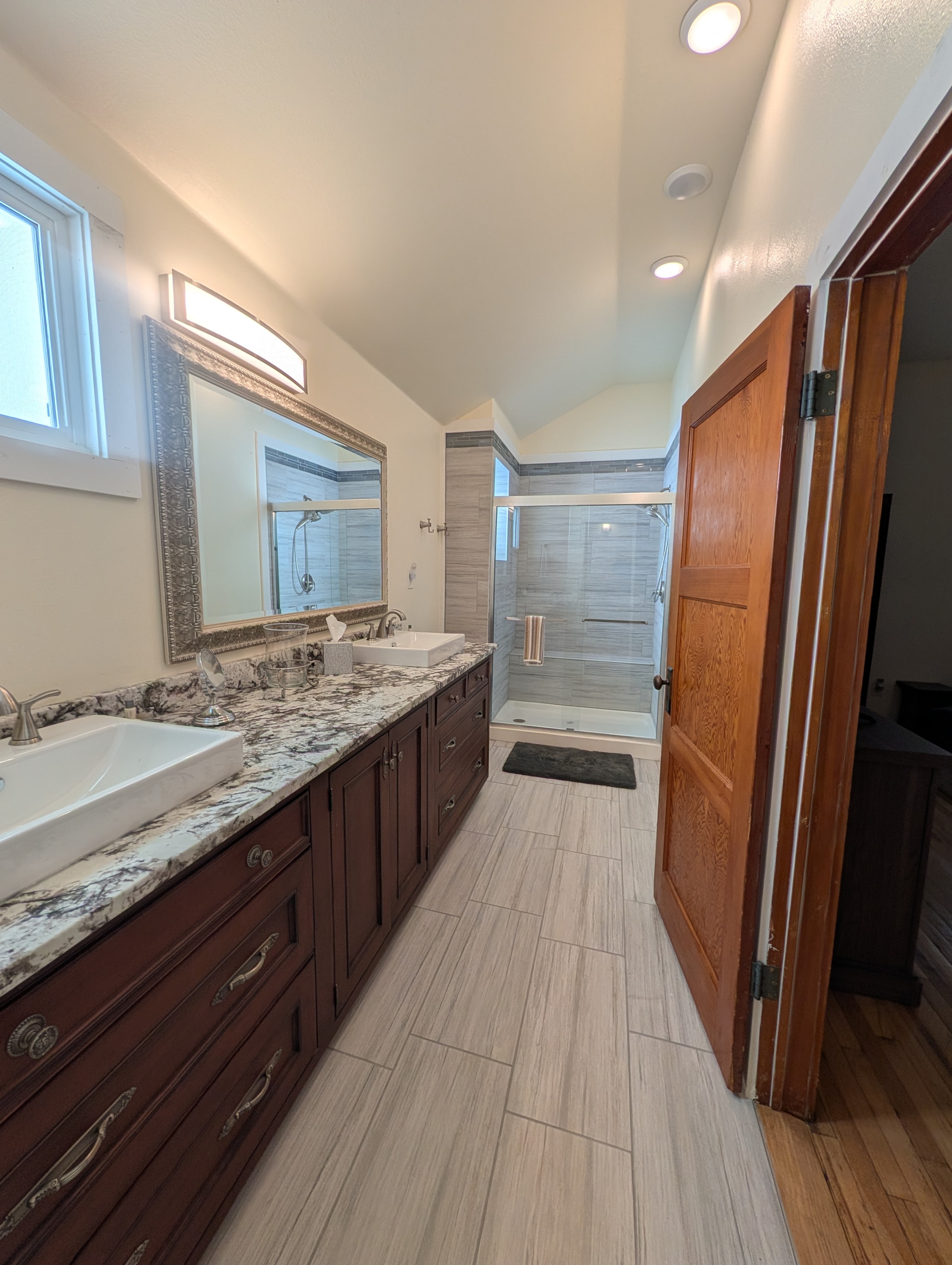 Master bathroom with double vanity, granite countertops, and walk-in shower