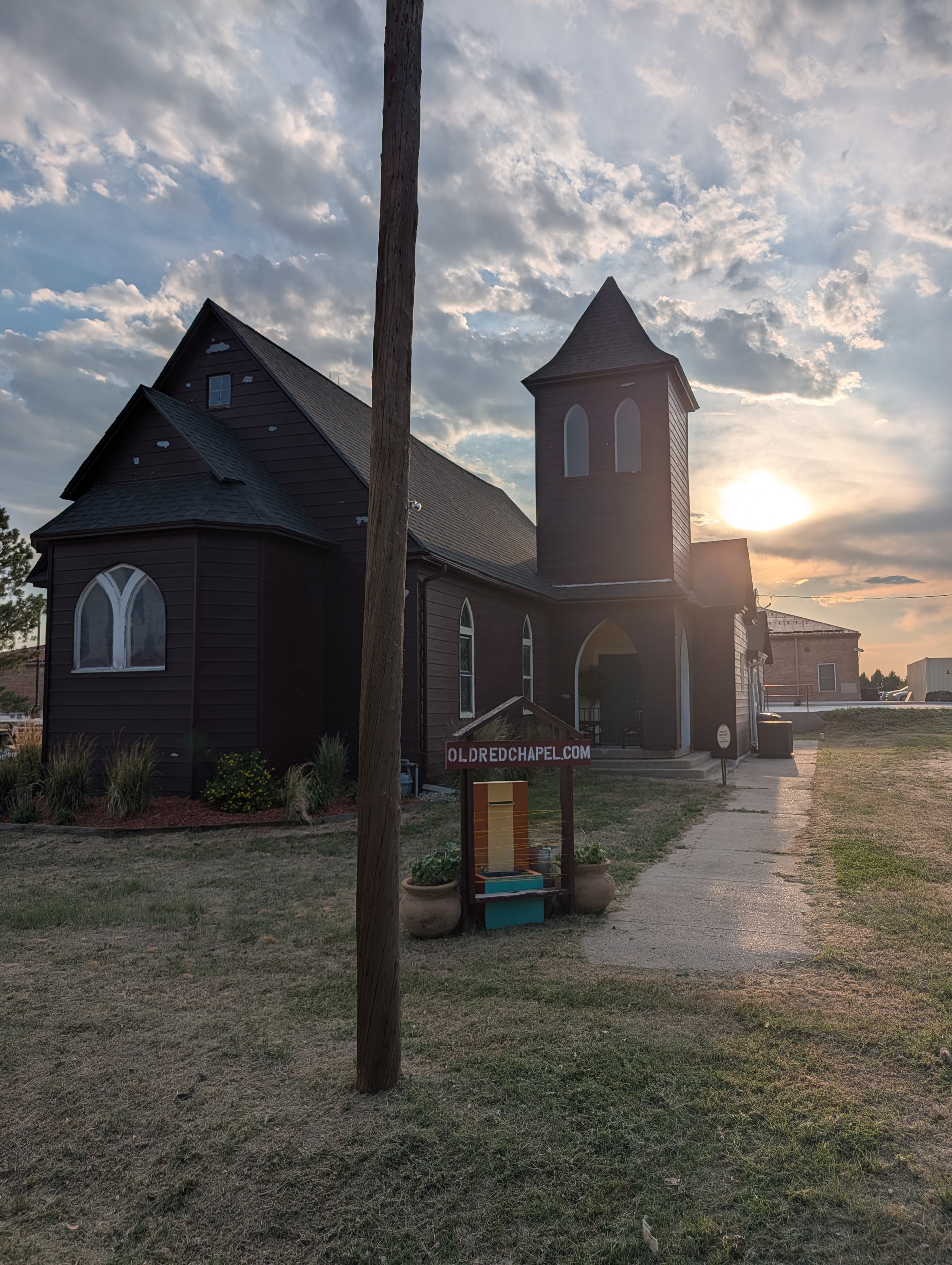 Old Red Chapel at sunset with OLDREDCHAPEL.COM sign and dramatic sky