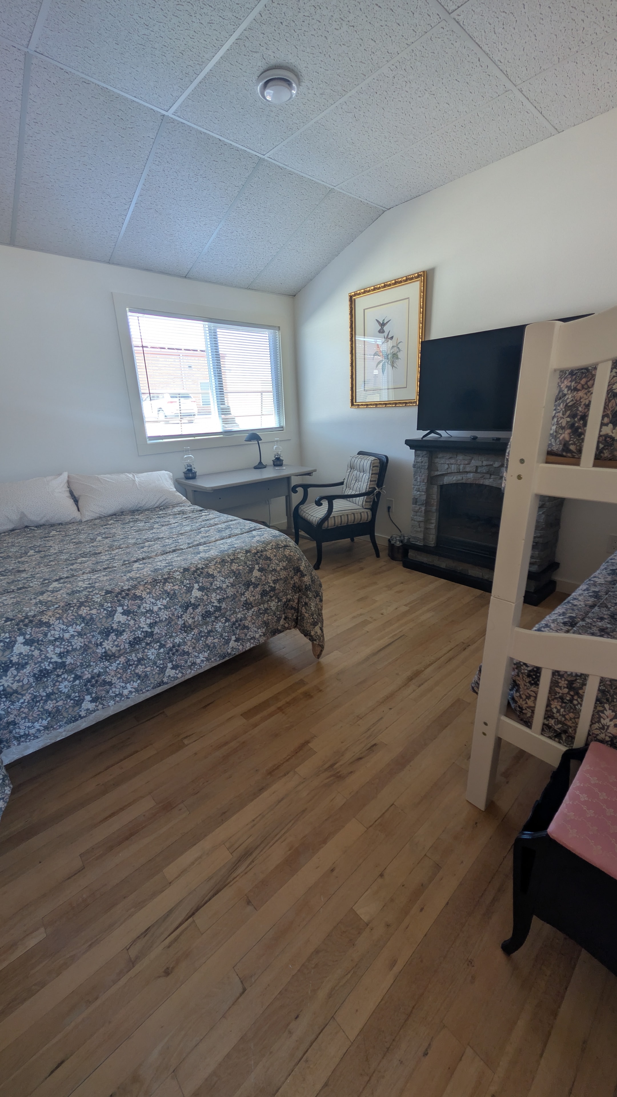 Bedroom with queen bed, bunk beds, and fireplace